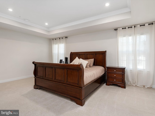 bedroom featuring light carpet and a tray ceiling