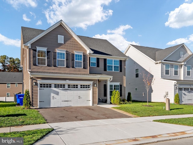 view of property featuring a front lawn and a garage