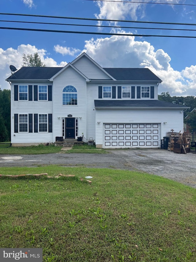 view of property featuring a garage and a front lawn