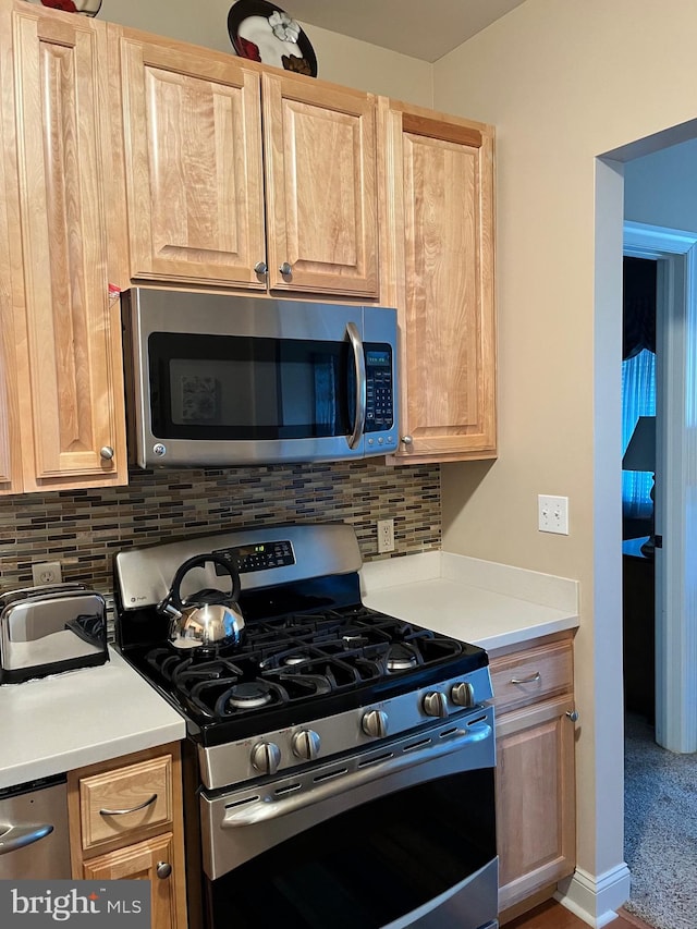 kitchen with tasteful backsplash, stainless steel appliances, and light brown cabinets