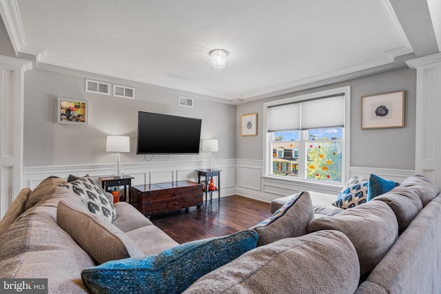 living room featuring dark wood-type flooring, ornate columns, and crown molding