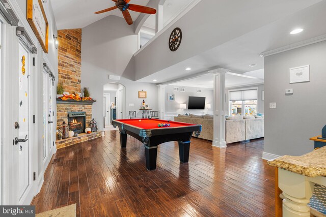 game room featuring dark wood-type flooring, vaulted ceiling, a brick fireplace, billiards, and ceiling fan