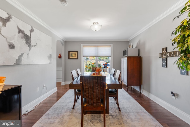 dining area featuring ornamental molding and dark wood-type flooring