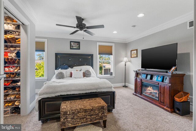 carpeted bedroom featuring crown molding and ceiling fan