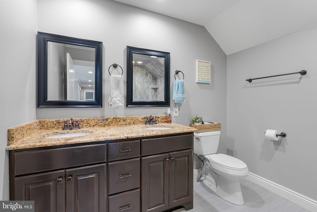 bathroom featuring vanity, toilet, tile patterned floors, and vaulted ceiling