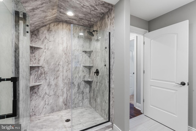 bathroom with an enclosed shower, hardwood / wood-style flooring, and lofted ceiling