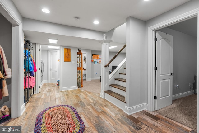 foyer entrance featuring light hardwood / wood-style floors and ornate columns