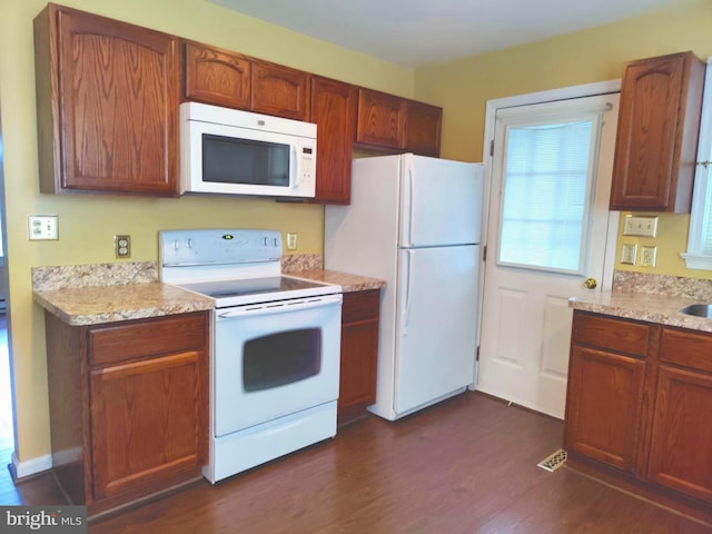 kitchen featuring dark hardwood / wood-style floors and white appliances