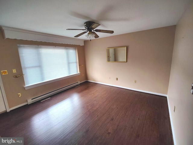 spare room featuring dark wood-type flooring, ceiling fan, and a baseboard heating unit