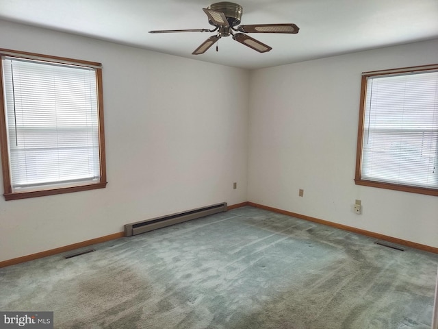 unfurnished room with carpet, plenty of natural light, ceiling fan, and a baseboard radiator