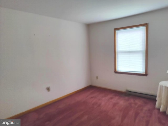 spare room with dark carpet and baseboard heating