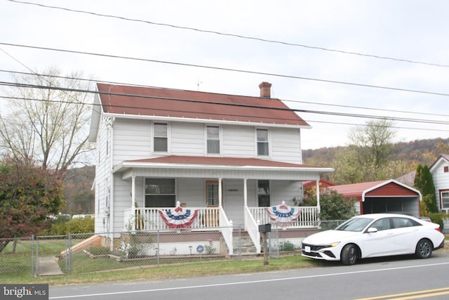 view of front of house featuring a detached carport, a porch, and fence private yard