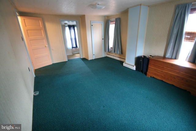 spare room featuring a baseboard radiator, carpet flooring, and a textured ceiling