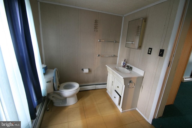 bathroom with tile patterned flooring, baseboard heating, vanity, crown molding, and toilet