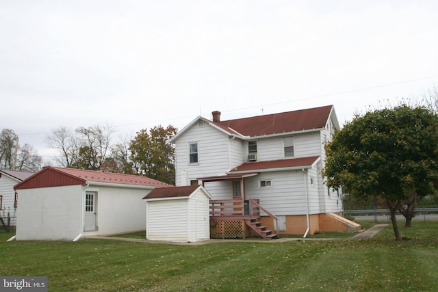 back of property featuring a storage unit and a lawn