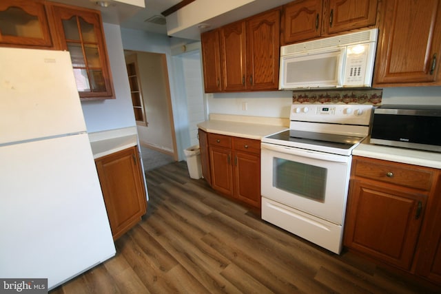 kitchen featuring white appliances and dark hardwood / wood-style floors