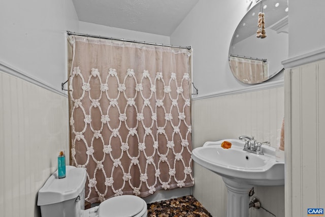 bathroom featuring toilet, a textured ceiling, and a shower with shower curtain