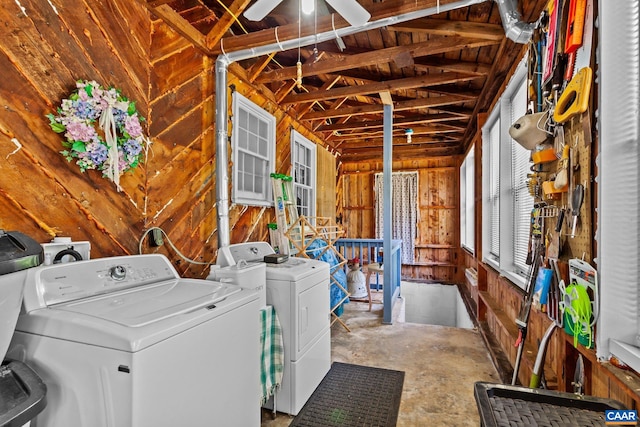 clothes washing area with wooden walls, separate washer and dryer, and ceiling fan