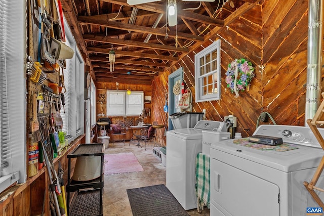 washroom featuring wood walls, washer and dryer, and ceiling fan