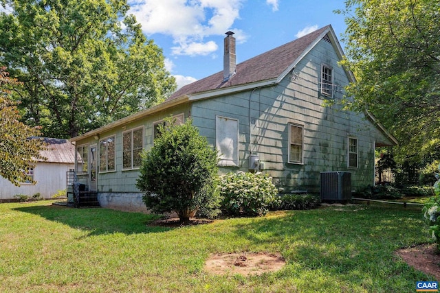 view of property exterior featuring central AC and a lawn