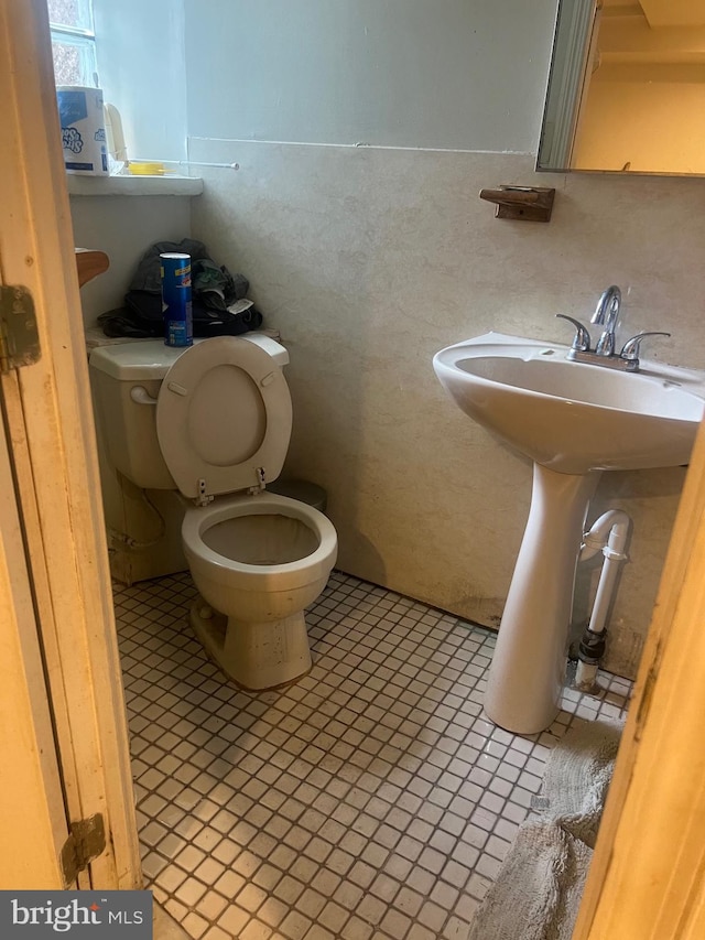 bathroom with toilet and tile patterned floors