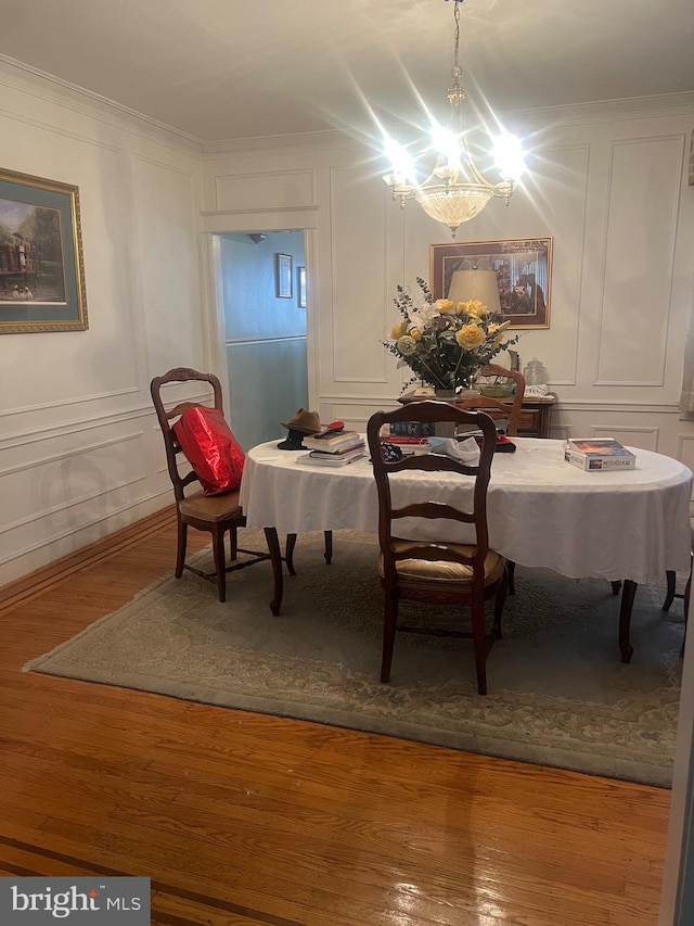 dining room featuring a chandelier, crown molding, and wood-type flooring