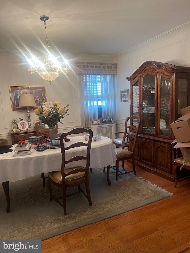 dining space featuring an inviting chandelier, crown molding, and hardwood / wood-style floors