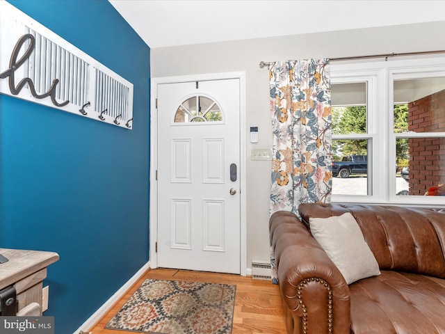 foyer entrance with hardwood / wood-style flooring and baseboard heating