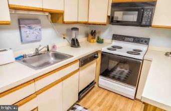 kitchen featuring white appliances, light countertops, and white cabinetry