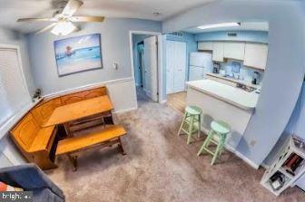 interior space with a ceiling fan and carpet flooring