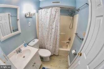 bathroom featuring toilet, shower / bath combo with shower curtain, and vanity