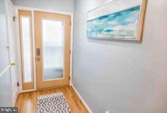 entryway featuring baseboards and light wood finished floors