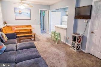 living area featuring carpet flooring and ceiling fan