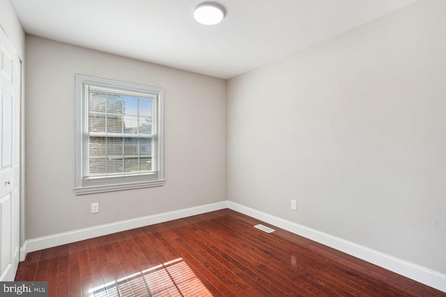 spare room with dark wood-type flooring