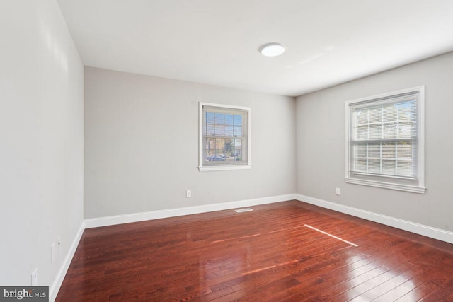 unfurnished room with dark hardwood / wood-style flooring