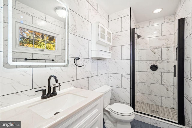 bathroom with tile walls, vanity, toilet, and a shower with door