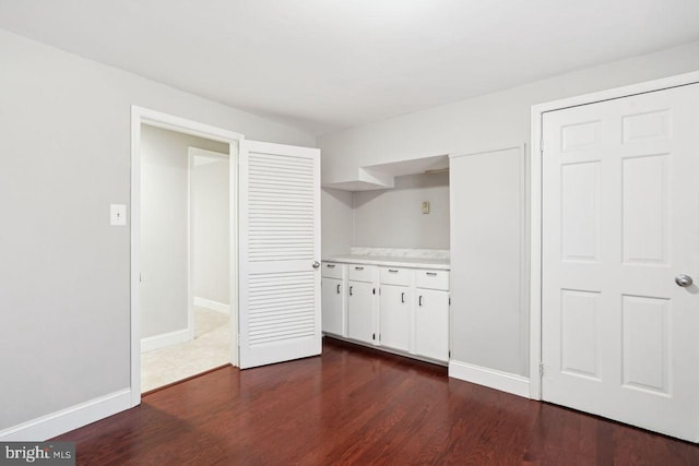 interior space featuring white cabinets and dark wood-type flooring