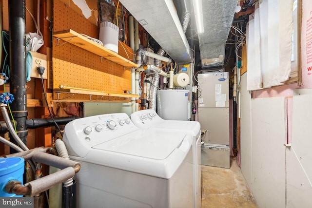 clothes washing area with water heater and washing machine and dryer