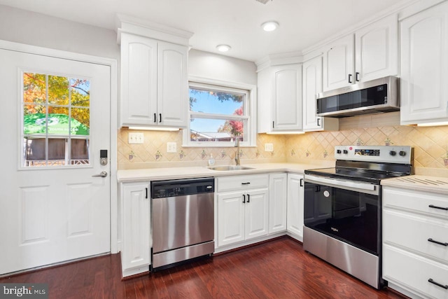 kitchen with dark hardwood / wood-style flooring, white cabinetry, appliances with stainless steel finishes, and plenty of natural light