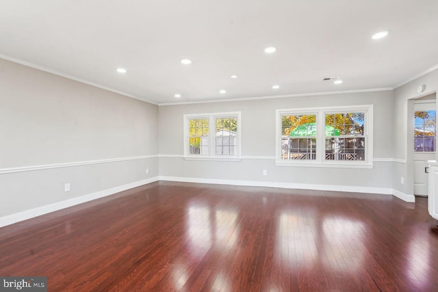 empty room with dark hardwood / wood-style floors and crown molding