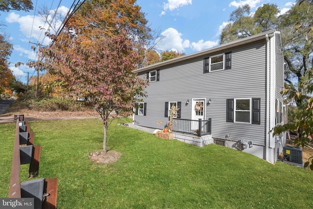 view of front of house with a front lawn and central AC