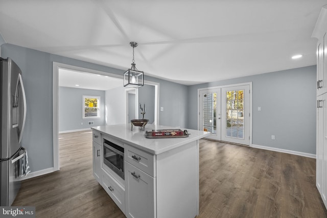 kitchen featuring a center island, white cabinets, stainless steel appliances, and plenty of natural light