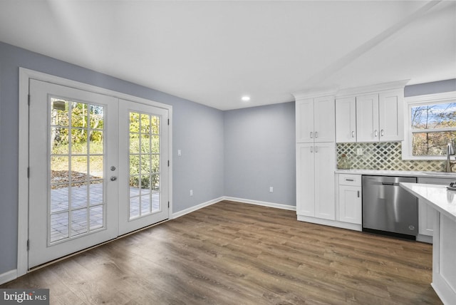 kitchen with french doors, dark hardwood / wood-style flooring, stainless steel dishwasher, and white cabinets