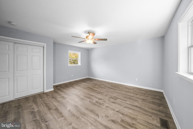 unfurnished bedroom featuring a closet, ceiling fan, and hardwood / wood-style flooring