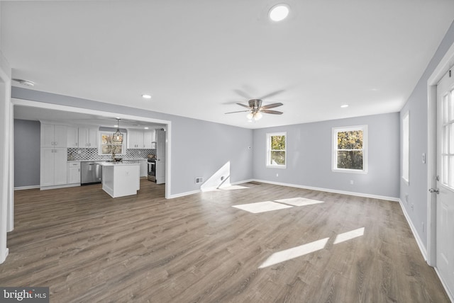 unfurnished living room with ceiling fan and hardwood / wood-style floors