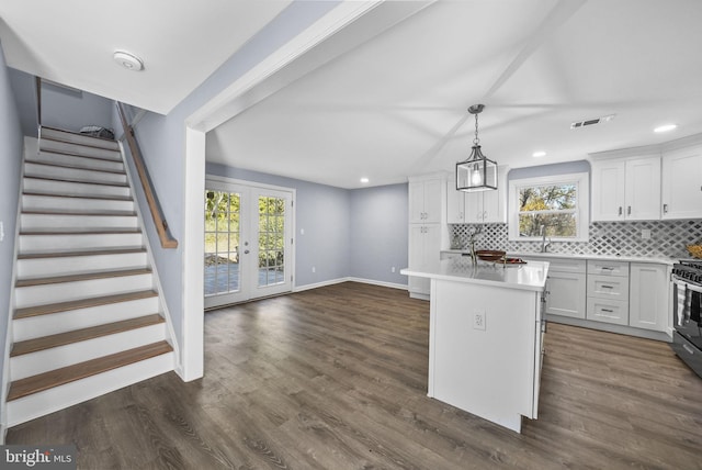 kitchen with a wealth of natural light, a center island, and white cabinetry