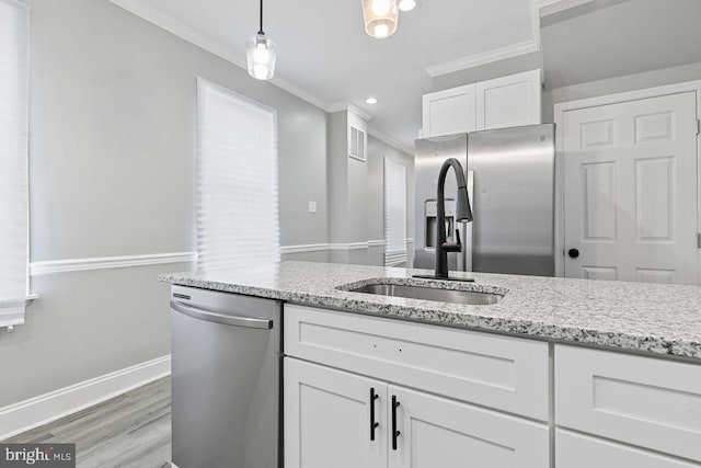 kitchen with appliances with stainless steel finishes, white cabinetry, light hardwood / wood-style floors, decorative light fixtures, and crown molding