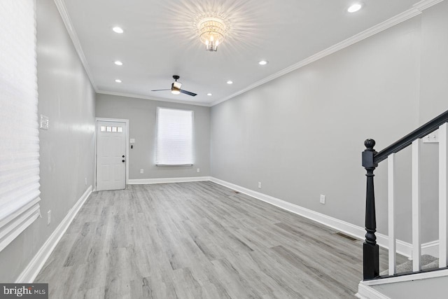 unfurnished living room featuring light hardwood / wood-style floors, ornamental molding, and ceiling fan with notable chandelier