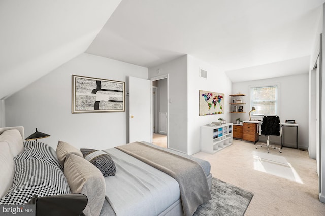 carpeted bedroom with lofted ceiling