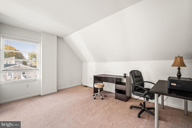 carpeted office space with vaulted ceiling